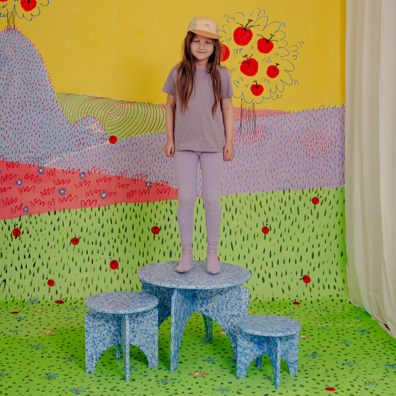 KID ON M1N3 TABLE AS WELL AS M1N1 AND M1N2 STOOLS IN ARTIC BLUE BY THE MINIMONO PROJECT - BRAND FOR ECO FRIENDLY - PLAYFUL - MULTI FUNCTIONAL - SUSTAINABLE - HIGH QUALITY - CIRCULAR DESIGN FURNITURE FROM RECYCLED PLASTIC FOR BOTH ADULT AND CHILDREN MADE IN BERLIN GERMANY