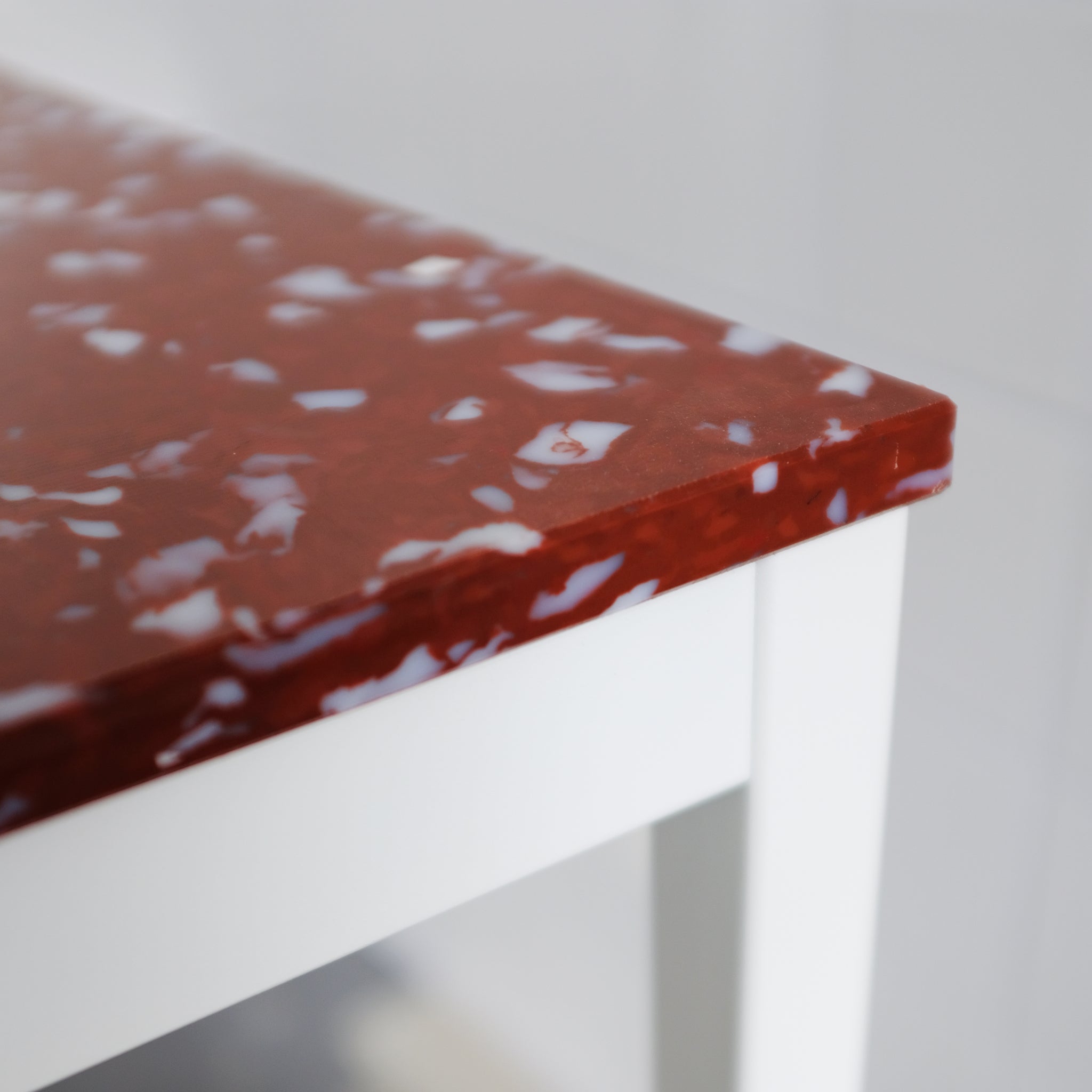 DETAIL OF RED TOP AND WHITE LEGS HIGH TABLE BY THE MINIMONO PROJECT - BRAND FOR ECO FRIENDLY - PLAYFUL - MULTI FUNCTIONAL - SUSTAINABLE - HIGH QUALITY - DESIGN FURNITURE FROM RECYCLED PLASTIC FOR BOTH ADULT AND CHILDREN MADE IN BERLIN GERMANY