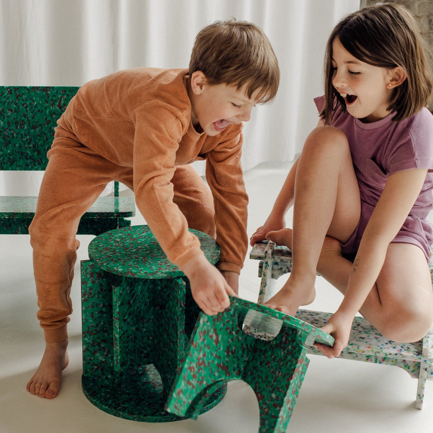 KIDS PLAYING WITH STOOLS BY THE MINIMONO PROJECT - BRAND FOR ECO FRIENDLY - PLAYFUL - MULTI FUNCTIONAL - SUSTAINABLE - HIGH QUALITY - DESIGN FURNITURE FROM RECYCLED PLASTIC FOR BOTH ADULT AND CHILDREN MADE IN BERLIN GERMANY